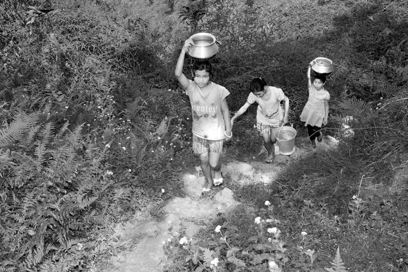 Children and Water - Girls carrying water up the hill from a protected spring in Tirap open cast coal mine area in Tinsukhia district, Assam
